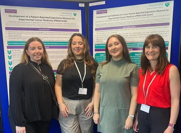 A photo of 4 women from the Christie Patient Centred Research team standing in front of a poster at a conference.