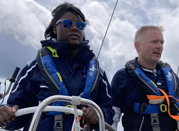 A photo of Christie patient Mercy wearing sunglasses and steering a boat.
