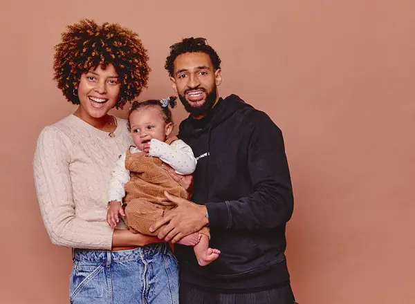 A photo of Christie patient Paige with her partner Deano and their baby.